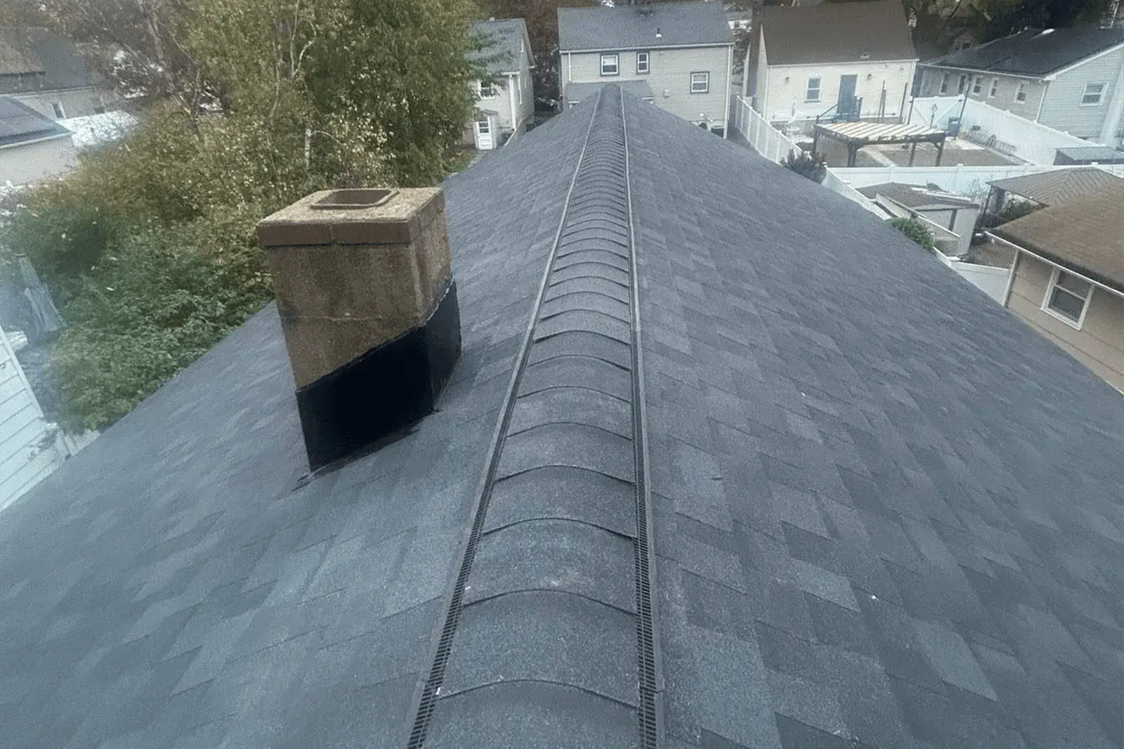 Completed Vesta shingle roof with ridge vent and chimney flashing