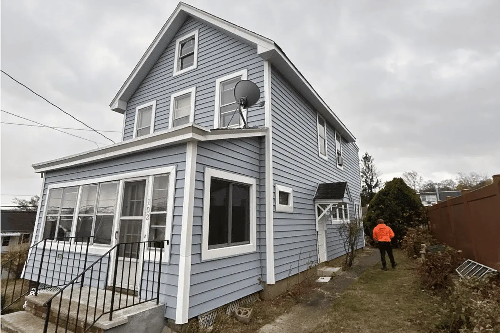 Vesta exterior renovation with gray siding, white window trim and an enclosed porch